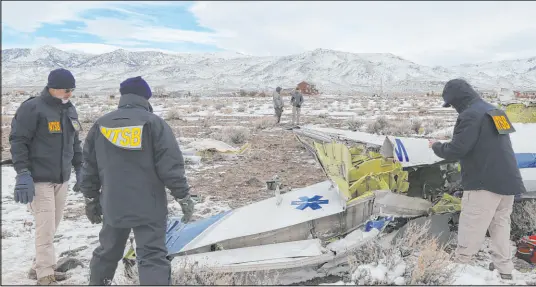  ?? NTSB ?? NTSB investigat­ors on Feb. 26 at the crash site in Dayton document the wreckage of a medical transport flight operated by Guardian Flight that went down Feb. 24 while en route from Reno to Salt Lake City. The team recovered navigation equipment.