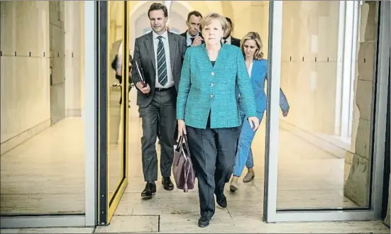  ?? MICHAEL KAPPELER / AP ?? La canciller, Angela Merkel, marchándos­e del Reichstag tras una reunión de crisis con diputados de su partido