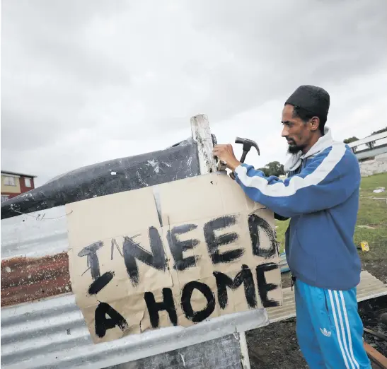  ?? Picture: Reuters ?? THE PEOPLE HAVE SPOKEN. Father of seven Muneer Baxter works on a shack erected during illegal land occupation­s in Mitchells Plain township Cape Town.