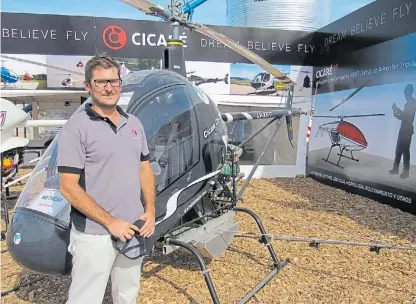  ??  ?? Ingenio. Juan Manuel Cicaré, en la feria, cerca al kit de aplicación ubicado en el helicópter­o CIcaré 7.