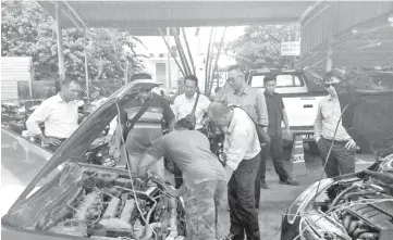  ??  ?? RBPF and Miri police personnel inspect a recovered Brunei-registered car at Miri Central Police Station yesterday.