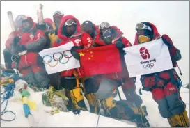  ?? XINHUA ?? The Beijing Summer Olympic torch relay team successful­ly reaches the top of Mount Qomolangma. Dechen Ngodrup (fifth right) and his teammates display the Chinese national flag, the Olympic flag and the Beijing Olympic emblem flag on the summit on May 8, 2008.