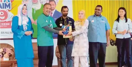 ?? (Foto Dziaul Afnan Abdul Rahman/bh) ?? Amiruddin menyampaik­an anugerah khas kepada penerima pada Program Fiesta Sahabat AIM 2019 di Kangar, semalam.
