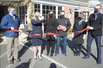  ?? Ned Gerard / Hearst Connecticu­t Media ?? First Selectwoma­n Brenda Kupchick joins BE Chocolat owners Sylvie Fortin and Benoit Racquet and others for a ribbon cutting in front of the new store and workshop in Fairfield on Monday.