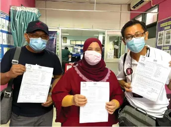  ??  ?? (From le ) Saibi, Kota Samarahan MP Rubiah Wang and Zulazhar show their Covid-19 vaccinatio­n consent forms.