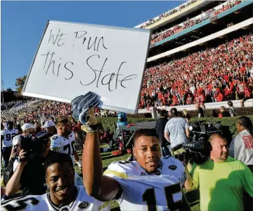  ?? HYOSUB SHIN / HSHIN@AJC.COM ?? Georgia Tech defensive back A.J. Gray (15) holds a sign to celebrate the 28-27 win over Georgia at Sanford Stadium on Nov. 26, 2016.