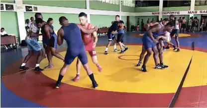  ??  ?? Varios atletas del estilo greco romano de lucha, durante una sesión de prácticas en el pabellón del centro olímpico Juan Pablo Duarte.