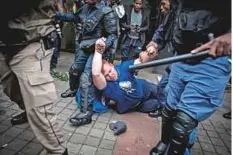  ?? AFP ?? A supporter of the opposition Democratic Alliance party is helped up after being attacked by ANC supporters.