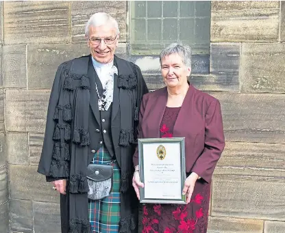  ??  ?? Marjory McHattie received her award from the Moderator of the General Assembly of the Church of Scotland, the Rt Rev Colin Sinclair.