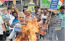  ??  ?? Protesters burn an effigy of Prime Minister Narendra Modi during a rally in Kolkata against the government’s Land Acquisitio­n Bill, calling it anti-farmer.