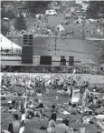  ?? ?? The stage (center) is empty — and likely to remain so — but thousands of rock-happy youngsters are sitting tight on the grass and in tents and caravans (beyond) at Powder Ridge ski area in Middlefiel­d. Though the music lovers were told the planned weekend rock festival was canceled, more than 30,000 showed up. Left, campers are set up by early arrivals as Powder Ridge becomes another instant Rock City.