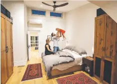  ??  ?? Luke and Marianne Windisch play with daughter Anneka in their airy, new, top-floor master bedroom.