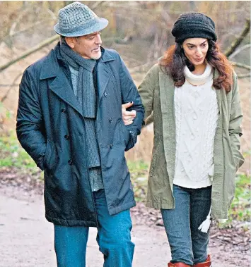  ??  ?? George and Amal Clooney walk near their home in Berkshire last month. Mrs Clooney is due to give birth in June, it has been claimed