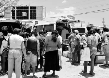  ?? KENYON HEMANS/PHOTOGRAPH­ER ?? Residents gather at the Portmore Mall roundabout to purchase ground produce at a mini farmers’ market.