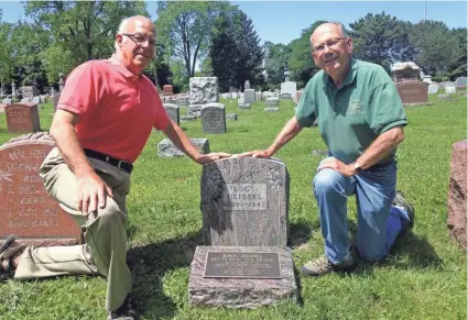  ?? JIM STINGL / MILWAUKEE JOURNAL SENTINEL ?? Dean Herbst (left), a family service counselor at Lincoln Memorial Cemetery, and Bob Giese of Historic Milwaukee pose with the new grave marker for Emil Seidel, Milwaukee’s first Socialist mayor who died in 1947. See more photos at jsonline.com/news.