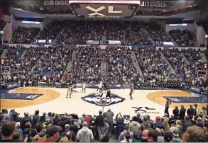  ?? Jessica Hill / Associated Press ?? UConn and Providence tip off in a sell-out arena in the first half of an NCAA college basketball game on Dec. 18 in Hartford. UConn is considerin­g changes to combat the rise in COVID cases.