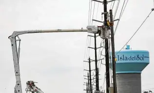  ?? Elizabeth Conley / Staff photograph­er ?? A utility worker repairs a power line Thursday on Galveston. The Legislatur­e has scheduled hearings starting next week on what caused the power grid crisis that left millions without heat.