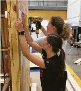  ?? Rice Architectu­re Construct ?? Julie Klosterman, foreground, and Rose Wilkowski install shiplap for part of the unit’s interior.