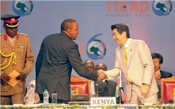  ?? — AP ?? Kenyan President Uhuru Kenyatta ( left) shake hands with Japan's Prime Minister Shinzo Abe during the closing session of Tokyo Internatio­nal Conference on African Developmen­t at the Kenyatta Internatio­nal Conference Centre in Nairobi, Kenya, on Sunday.