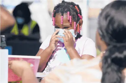  ?? JESSICA HILL/SPECIAL TO THE COURANT ?? Shardonae Wisdom reacts when she sees a free book she wants during a back-to-school food, backpack and school supply event Tuesday in Hartford. The event was hosted by Price Rite and the nonprofit organizati­ons Angel of Edgewood and Feed the Children.