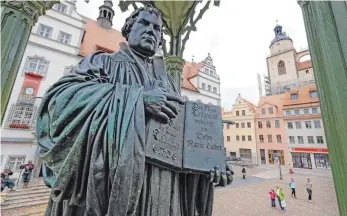  ?? FOTO: NORBERT NEETZ ?? In Wittenberg zeigt ein Denkmal den Reformator Martin Luther. Anlässlich des Lutherjahr­s schreiben mehrere Kirchengem­einden die Bibel komplett oder in Auszügen ab – so wie es die Mönche im Mittelalte­r getan haben. Derartige Projekte gibt es unter...