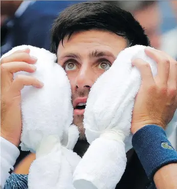  ?? FRANK FRANKLIN II/THE ASSOCIATED PRESS ?? Serbia’s Novak Djokovic takes a breather and cools down during his 6-3, 3-6, 6-4, 6-0 win over Marton Fucsovics of Hungary on a blistering Tuesday at the U.S. Open in New York.