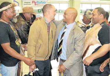  ?? Picture: FREDLIN ADRIAAN ?? HEARTFELT HOMECOMING: Chief Wallace Williams, centre left, and MPL Christian Martin hug at the Port Elizabeth airport
