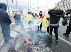  ?? FRANK GUNN / THE CANADIAN PRESS ?? Striking Canada Post workers walk the picket line at the giant mail-sorting plant in Mississaug­a, Ont., on Tuesday.