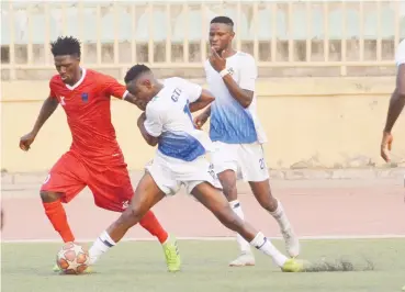  ??  ?? Issa Gata of Kwara United (white jersey) fights for the ball with Lobi Stars midfielder, Douglas Achiv during their match in Ilorin