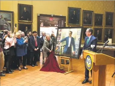  ?? Susan Haigh / Associated Press ?? Outgoing Gov. Dannel P. Malloy, right, and his wife, Cathy, center, unveil the Democrat’s official state portrait during a ceremony at the Museum of Connecticu­t History in Hartford on Thursday. The Democrat leaves office on Jan. 9.