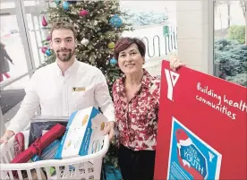  ?? BOB TYMCZYSZYN
THE ST. CATHARINES STANDARD ?? YMCA’s Nathan Smith and FACS Niagara’s Ann Godfrey at the Walker family YMCA with donations for the Cool Yule Program for youth transition­ing from foster care.