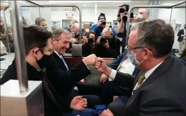 ?? (AP/Alex Brandon) ?? Michael van der Veen (second from left), one of the attorneys for former President Donald Trump, fist-bumps a colleague Saturday as they depart on the Senate subway after Trump’s acquittal.