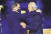  ?? ANDREW HARNIK AP ?? President-elect Joe Biden (right) embraces his son Hunter Biden in Wilmington, Del.