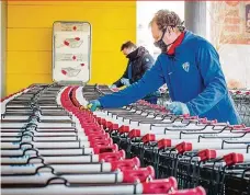  ?? Foto: Petr Lundák, MAFRA ?? Dezinfekce nákupních košíků Fotbalem teď třetiligov­é Táborsko potěšit nemůže, tak pomáhá s obranou proti koronaviru. Na snímku blíže kustod Petr Kolář a v pozadí trenér Miloslav Brožek.