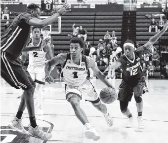  ?? STAFF FILE PHOTO BY ROBIN RUDD ?? UTC’s Rodney Chatman, center, scored a career-high 26 points Saturday, but it wasn’t enough as the Mocs fell to East Tennessee State 81-61.