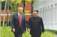  ??  ?? U.S. President Donald Trump and North Korean leader Kim Jong Un take a walk during a break at their historic summit in Singapore.