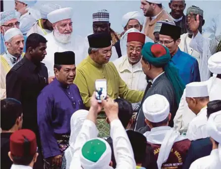  ?? FOTO: AIZUDDIN SAAD ?? DR Ahmad Zahid diiringi Jamil (baju ungu) beramah mesra bersama ulama dan mufti yang hadir, semalam.