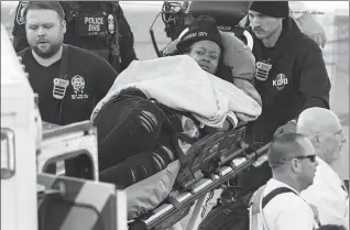  ?? CHARLIE RIEDEL / ASSOCIATED PRESS ?? An injured person is taken to an ambulance following a shooting at a Super Bowl celebratio­n event in Kansas City, Missouri, on Wednesday.