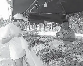 ?? FOTO: EL DIARIO ?? Bonifacio Chóez, encargado de un puesto de venta de dulces, mientras atendía a un cliente que llegó ayer en horas de la tarde.