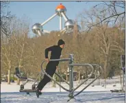  ?? (File Photo/AP/Francisco Seco) ?? A man exercises Feb. 9 at a public gym next to the Atomium after a snowfall at a park in Brussels.