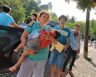  ?? Photo by YAS D. OCAMPO MindaNews ?? NENITA RAGANET, carrying baby Jessa Mae, arrives at the Incident Command Post in Barangay Elizalde in Maco. She has lost 13 of her relatives in the landslide.