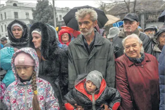  ?? BULENT KILIC / AFP ?? Ciudadanos de Jersón, pasando frío bajo la lluvia y esperando un reparto de alimentos por parte de organizaci­ones humanitari­as.