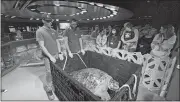  ?? RODRIQUE NGOWI/AP PHOTO ?? New England Aquarium staff and visitors looking at Myrtle as the massive sea turtle rests in a crate after being hoisted out of a giant ocean tank before a medical examinatio­n in Boston on Tuesday.