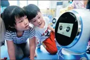  ?? HU DONGDONG / FOR CHINA DAILY ?? Children play with an intelligen­t robot at a kindergart­en in Wuhan, capital of Hubei province.