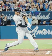  ?? TOM SZCZERBOWS­KI GETTY IMAGES ?? Giancarlo Stanton hits a home run on Opening Day in Toronto.