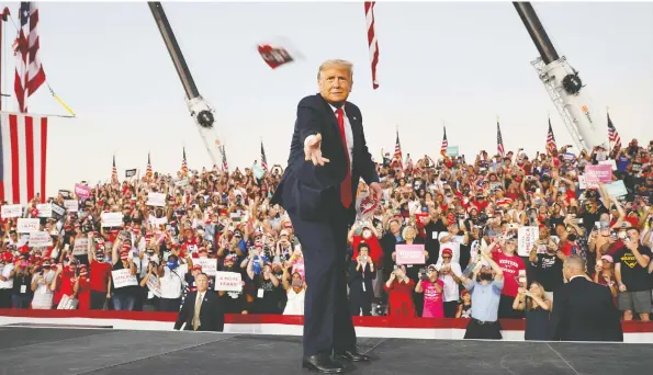  ?? JONATHAN ERNST / REUTERS ?? U.S. President Donald Trump throws a face mask from the stage during a rally in Sanford, Fla., on Monday, his first since campaign trip being treated for COVID-19.