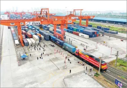  ?? PHOTOS BY TANG YI / XINHUA ?? Containers being loaded onto a freight train at the Tuanjiecun station in Southwest China’s Chongqing municipali­ty on Sept 1.