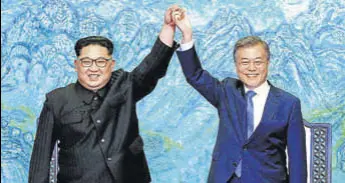  ?? AP FILE ?? North Korean leader Kim Jong Un (left) and South Korean President Moon Jaein raise their hands after signing a joint statement at the border village of Panmunjom on April 27.