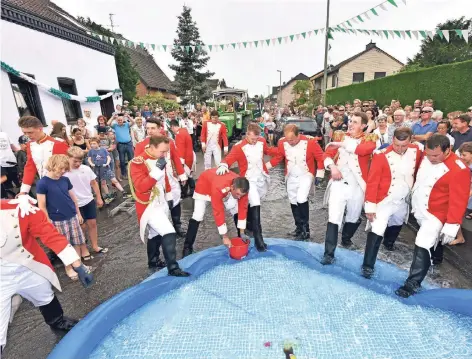  ?? FOTOS: JÖRG SCHIMMEL UND OLEKSANDR VOSKRESENS­KYI ?? Beim Umzug bilden die Sappeure die Vorhut. Sie haben laut Tradition alle von Nachbarn und Vereinen errichtete­n Barrikaden und Hinderniss­e wegzuräume­n, bevor der König kommt.