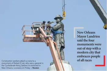  ?? — Reuters ?? Constructi­on workers attach a crane to a monument of Robert E Lee, who was a general in the Confederat­e Army, before it is removed in New Orleans, Louisiana on Friday.